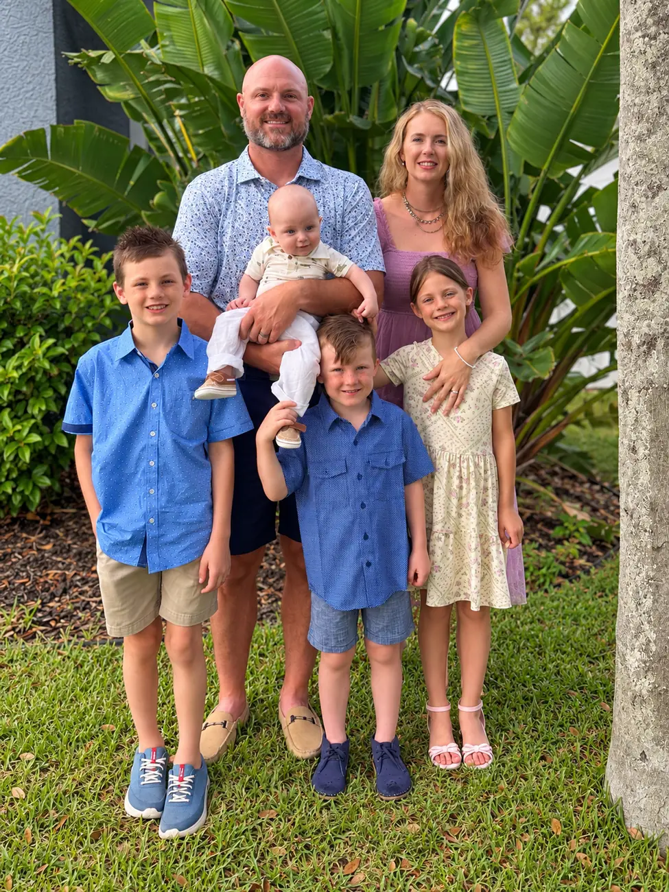 The Trapasso family standing together in a garden.