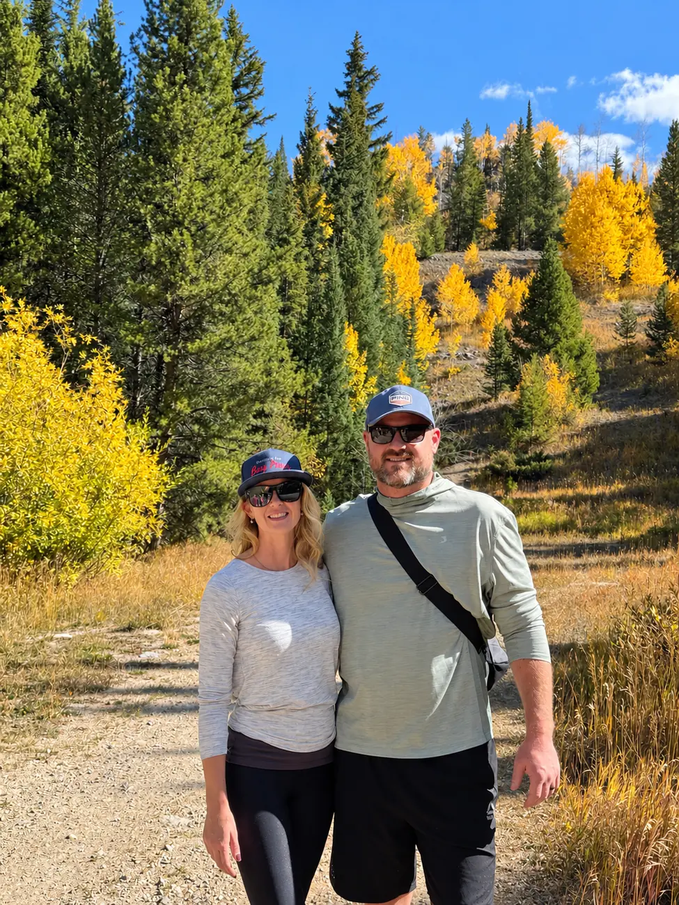 Kerri and A.J. Trapasso on a hiking trail among aspens and pines in Colorado.